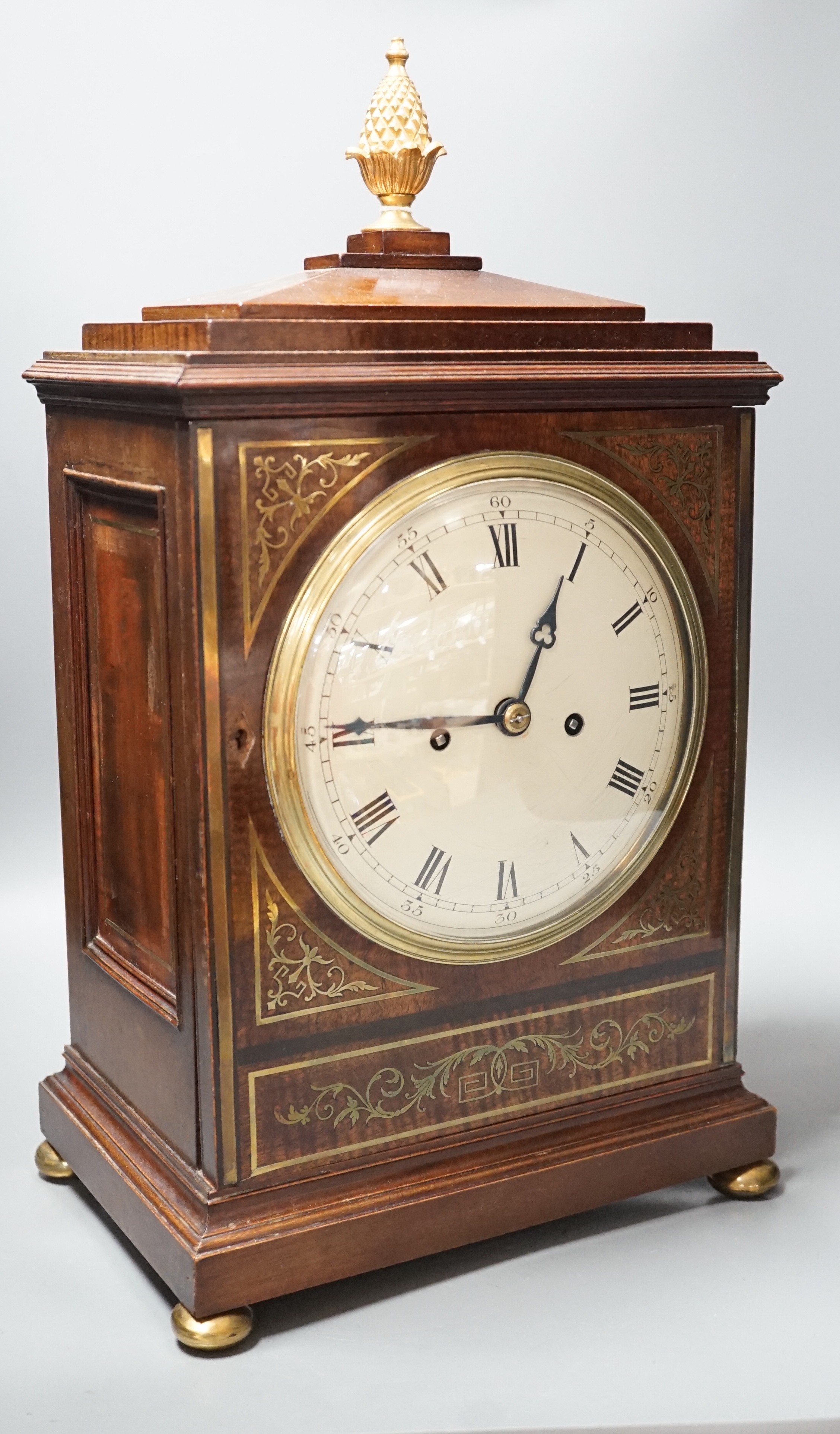 A Regency brass inlaid mahogany bracket clock, with pineapple finial, bears interior paper label Cuss & Co. 49cm high